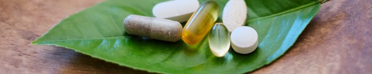 Gélules de compléments alimentaires présentées avec des ingrédients naturels